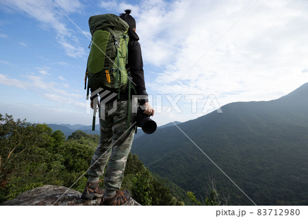 Successful hiker enjoy the view on mountain top cliff edge 83712980