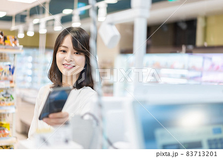 セルフレジ・電子マネー決済をする若い女性 83713201