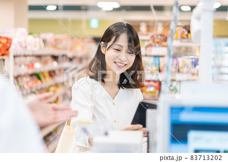 セルフレジ・電子マネー決済をする若い女性 83713202