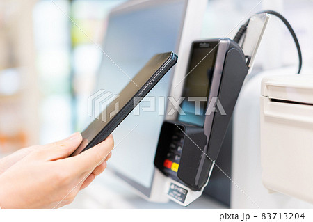 セルフレジ・電子マネー決済をする若い女性 83713204