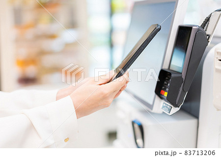セルフレジ・電子マネー決済をする若い女性 83713206