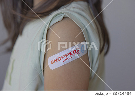 Calgary, Alberta, Canada. Nov 6, 2021. An little girl with a Vaccine Shoppers Drug Mart Adhesive bandage Calgary, Alberta, Canada. Nov 6, 2021. An little girl with a Vaccine Shoppers Drug Mart Adhesive bandage 83714484