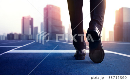 Start, Competition Concept. Low Section of Businessman Steps into Start Line on Running Track and Moving Forward to New Challenge. Blurred City Building as background 83715360