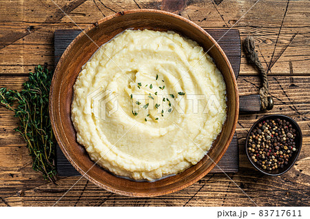 Mashed potatoes, boiled puree in a wooden plate. Wooden background. Top view Mashed potatoes, boiled puree in a wooden plate. Wooden background. Top view 83717611