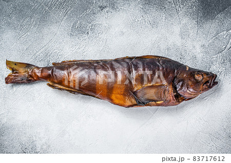Hot smoked whole fish on kitchen table. White background. Top view Hot smoked whole fish on kitchen table. White background. Top view 83717612