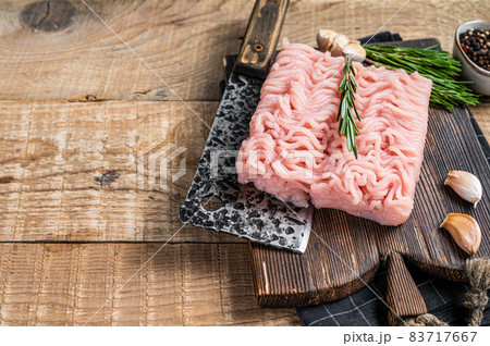 Raw minced chicken and turkey meat on wooden chopping board with butcher cleaver. wooden background. Top view. Copy space 83717667