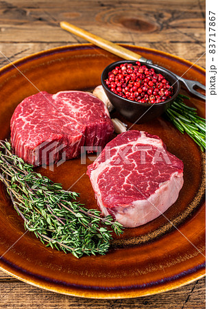Raw Fillet Mignon tenderloin meat beef steaks on rustic plate. wooden background. Top view 83717867