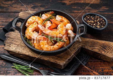 Roast Prawns Shrimps in a pan with herbs and garlic. Dark wooden background. Top view 83717877