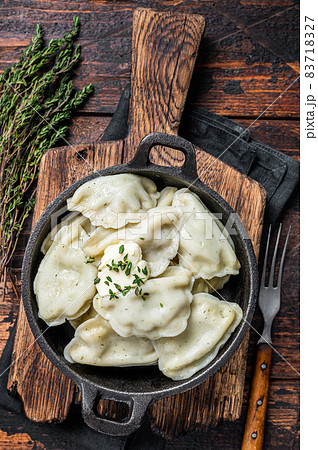 Homemade dumplings, vareniki, pierogi stuffed with potato in a pan. Dark wooden background. Top View 83718327