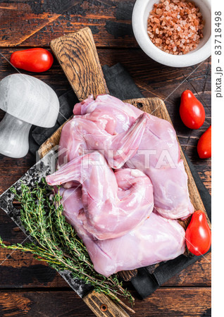 Raw hare legs on a butcher board with thyme. Dark wooden background. Top view 83718498