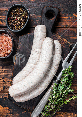 Munich traditional white sausages on a wooden board with thyme. Dark wooden background. Top view 83718669