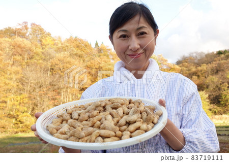 収穫した落花生を持つ中年女性 83719111