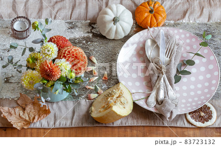 Festive table setting with pumpkins, candles and chrysanthemum flowers. Festive table setting with pumpkins, candles and chrysanthemum flowers. 83723132