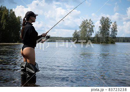 Sexy female fisher standing in lake Sexy female fisher standing in lake 83723238