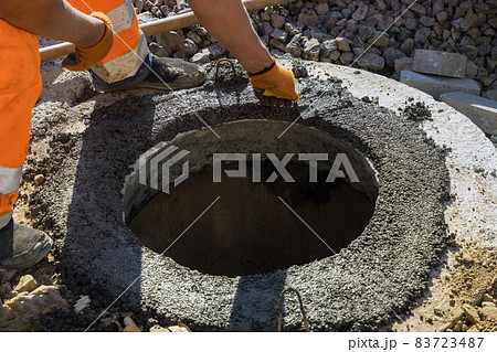 A worker the new road construction work on preparation for installation of sewer hatches A worker the new road construction work on preparation for installation of sewer hatches 83723487