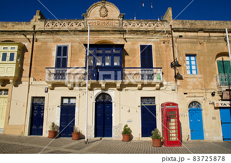 MARSAXLOKK, MALTA - 03 JAN, 2020: Classic red British telephone box at the traditional fishing village of Marsaxlokk MARSAXLOKK, MALTA - 03 JAN, 2020: Classic red British telephone box at the traditional fishing village of Marsaxlokk 83725878