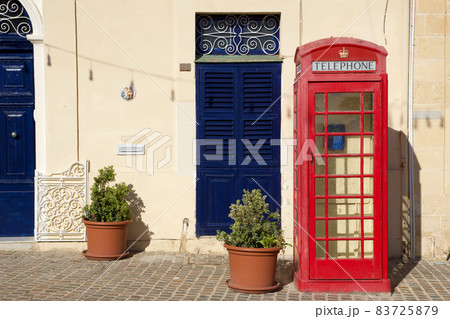 MARSAXLOKK, MALTA - 03 JAN, 2020: Classic red British telephone box at the traditional fishing village of Marsaxlokk MARSAXLOKK, MALTA - 03 JAN, 2020: Classic red British telephone box at the traditional fishing village of Marsaxlokk 83725879