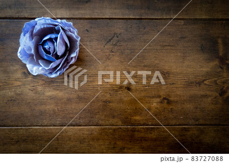 青紫のバラのコサージュとアンティークビンテージ調のレトロな茶色で木目のテーブル 青紫のバラのコサージュとアンティークビンテージ調のレトロな茶色で木目のテーブル 83727088