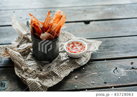 Dried chicken, dried poultry, cut into strips in a metal bucket on a wooden background. Serving a meal in a restaurant 83728063