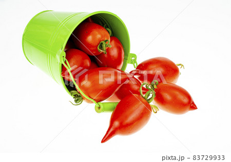 Harvesting. Red ripe tomatoes in colored buckets on white background. Studio Photo. 83729933