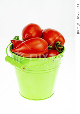 Harvesting. Red ripe tomatoes in colored buckets on white background. Studio Photo. 83729934