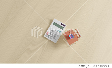 平面上に置かれたミニチュアのスクールデスクと電卓 83730993