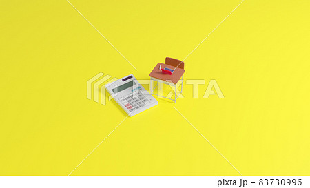 平面上に置かれたミニチュアのスクールデスクと電卓 83730996