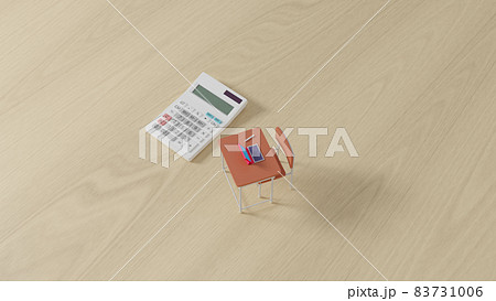 平面上に置かれたミニチュアのスクールデスクと電卓 83731006