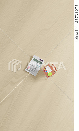 平面上に置かれたミニチュアのスクールデスクと電卓 平面上に置かれたミニチュアのスクールデスクと電卓 83731073