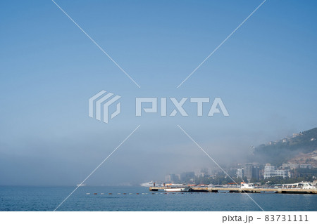 White ships stand on the dock near the coast in the fog 83731111