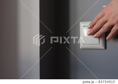 Hands push the switch on the wall, close-up 83734915