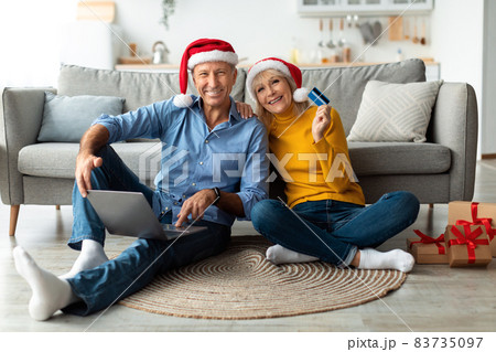 Spouses Showing Credit Card Using Laptop Shopping On Christmas Indoor 83735097