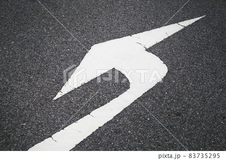 white direction arrow sign paint on black asphalt road surface. white direction arrow sign paint on black asphalt road surface. 83735295