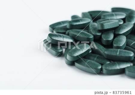 Pills with Vitamins and spirulina on a white background. Pills with Vitamins and spirulina on a white background. 83735961