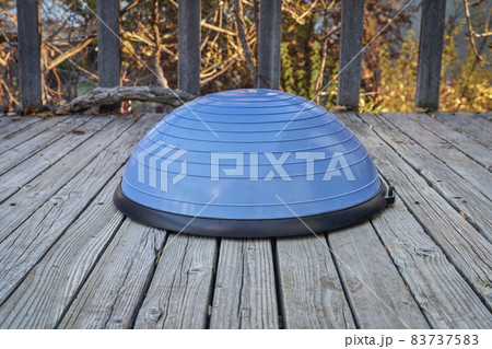 Balance training ball on wooden deck Balance training ball on wooden deck 83737583