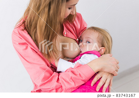 Young beautiful mother, breastfeeding her baby girl. Mom breastfeeding infant, close-up. 83743167