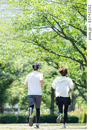 新緑の公園でジョギングするカップルの後ろ姿 83743262
