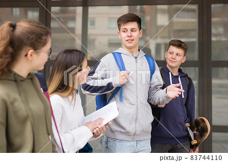 Carefree teen students walking outside school Carefree teen students walking outside school 83744110