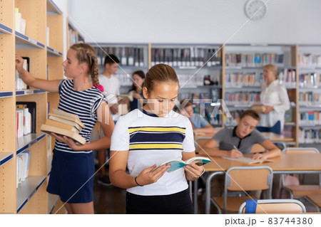 Portrait of fine schoolgirl holding books 83744380