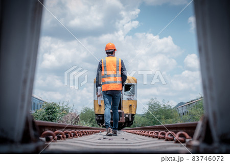 Engineer railway under checking construction process train testing and checking railway work on railroad station with radio communication .Engineer wearing safety uniform and safety helmet in work. Engineer railway under checking construction process train testing and checking railway work on railroad station with radio communication .Engineer wearing safety uniform and safety helmet in work. 83746072