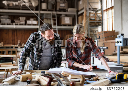 Two carpenters man and woman talking about design of products. Small business concept. 83752203