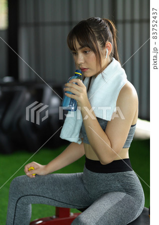 Exhausted fitness woman drinking water for hydrated herself after workout 83752437