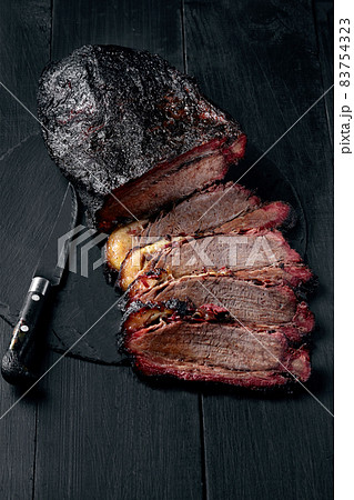 Fresh Brisket BBQ beef sliced for serving against a dark background Fresh Brisket BBQ beef sliced for serving against a dark background 83754323
