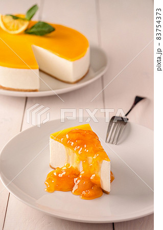 Orange Cake in white dish on the white wood table Orange Cake in white dish on the white wood table 83754373