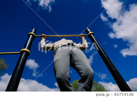 Caucasian sportsman on crossbar during street workout. Healthy lifestyle and street sport concept 83754536