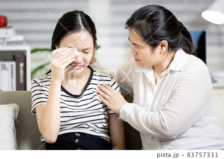 Stressed asian teenager girl crying,life problems with friends at school,disappointed by the love relationships breakup with boyfriend,mother embracing comforting and counselling a sad teenage student 83757331