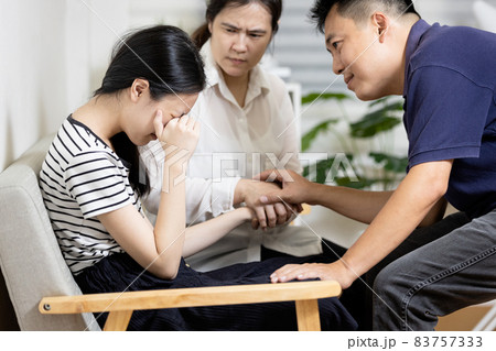 Asian parents give advice,talk sharing thoughts care to teenage girl,mom and dad holding hands to comfort and consoling daughter together,sad teenager student crying at home,family life relationship Asian parents give advice,talk sharing thoughts care to teenage girl,mom and dad holding hands to comfort and consoling daughter together,sad teenager student crying at home,family life relationship 83757333