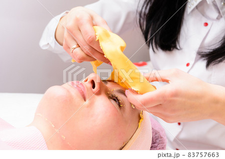 The process of removing the cosmetic golden mass, cosmetic procedures in the salon. The process of removing the cosmetic golden mass, cosmetic procedures in the salon. 83757663