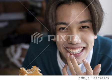 美味しそうにハンバーガーを食べる男性 美味しそうにハンバーガーを食べる男性 83758125
