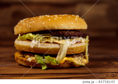 Delicious big hamburger on wooden table Delicious big hamburger on wooden table 83758145